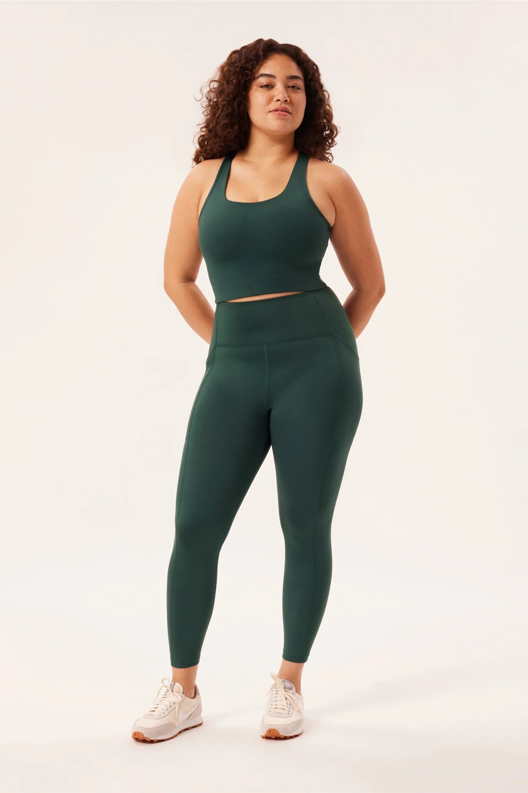 Model in green leggings and a matching sports bra