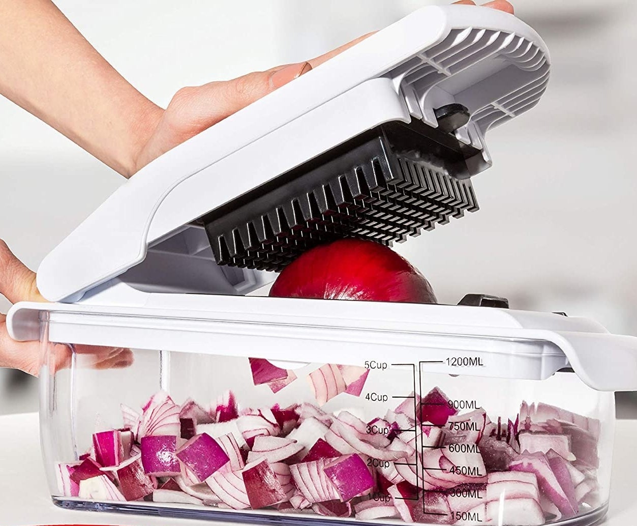 A person chopping onions with the gadget