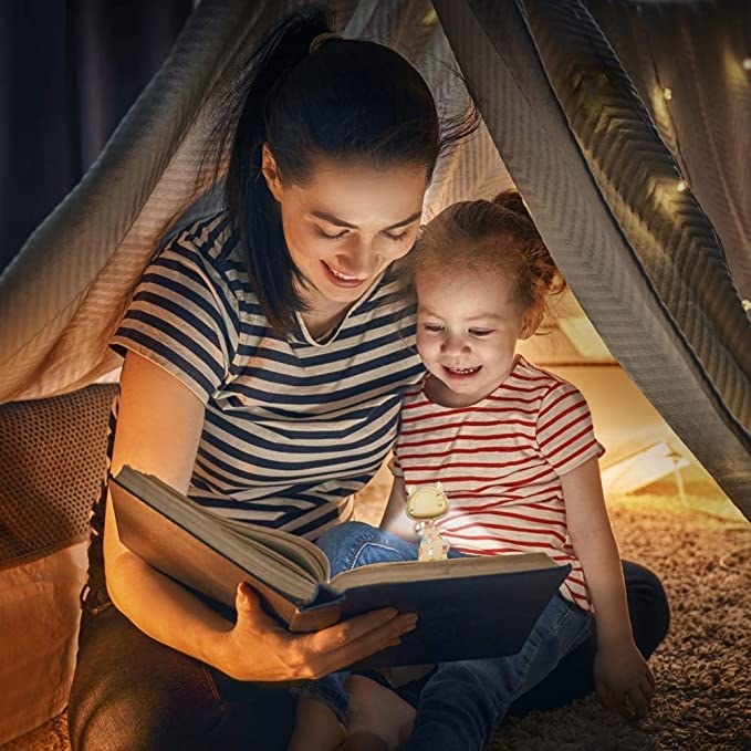 adult and child models reading a book with the book lamp