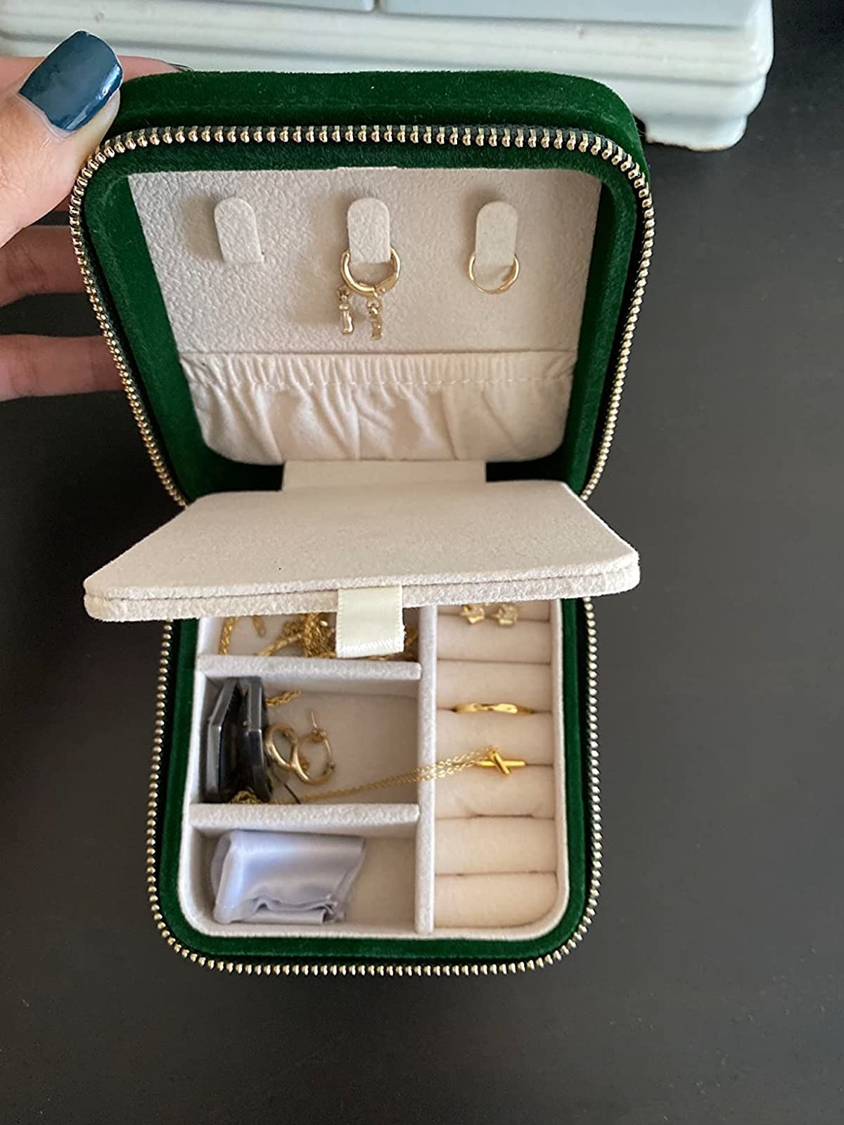 reviewer&#x27;s green velvet jewelry box filled with necklaces, earrings, and rings