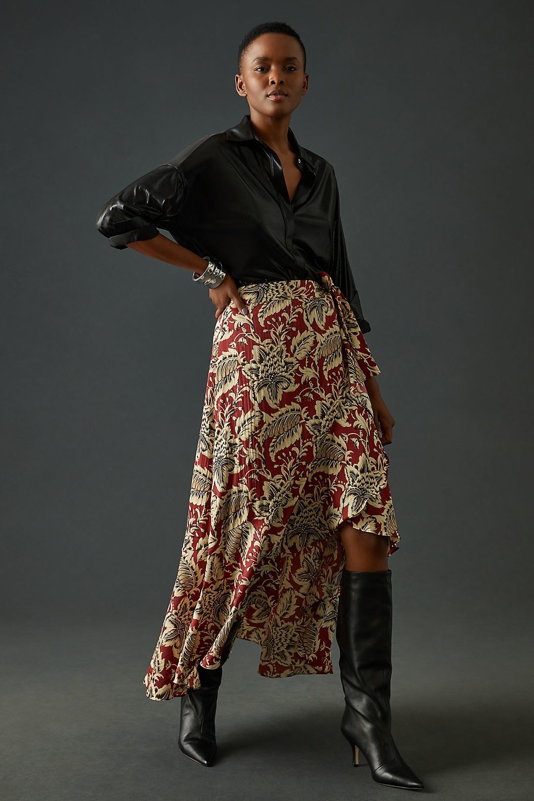 model in a red and cream patterned silky wrap skirt with an asymmetrical high low hem and tie at the waist