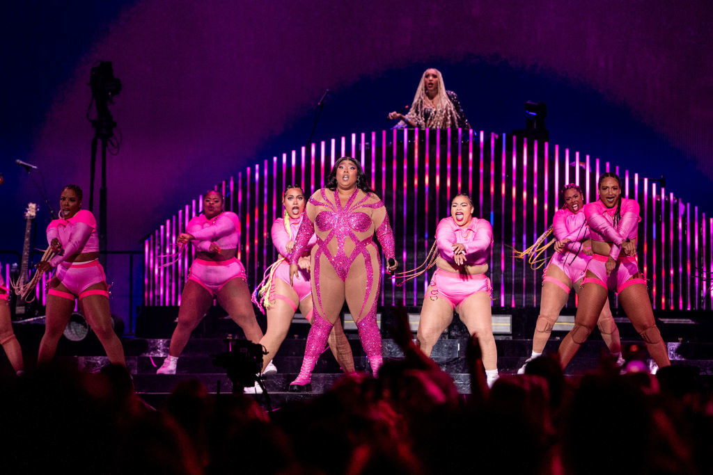 Lizzo performing onstage with backup dancers