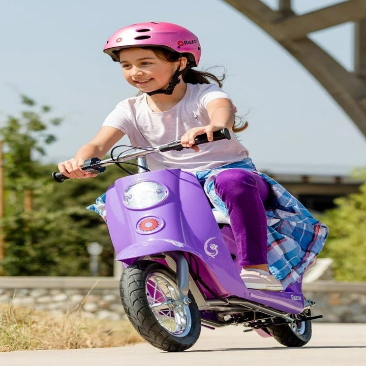 child riding the purple scooter