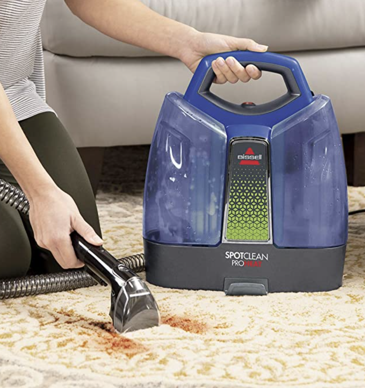 a person using the cleaner to suck up a stain on a rug
