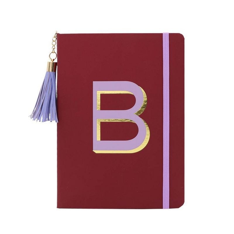 A maroon notebook with purple and gold B on it
