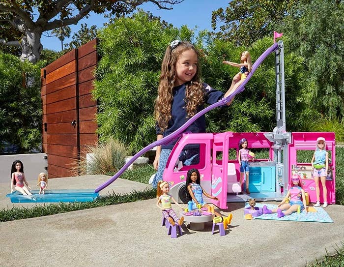 A kid playing with the RV toy outdoors