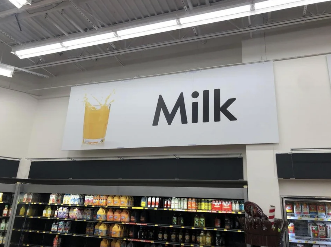 A sign with orange juice that says &quot;Milk&quot;