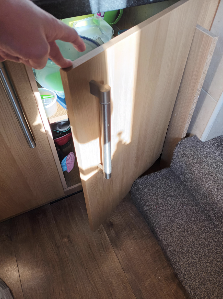 cabinet door being stopped by the stairs next to it