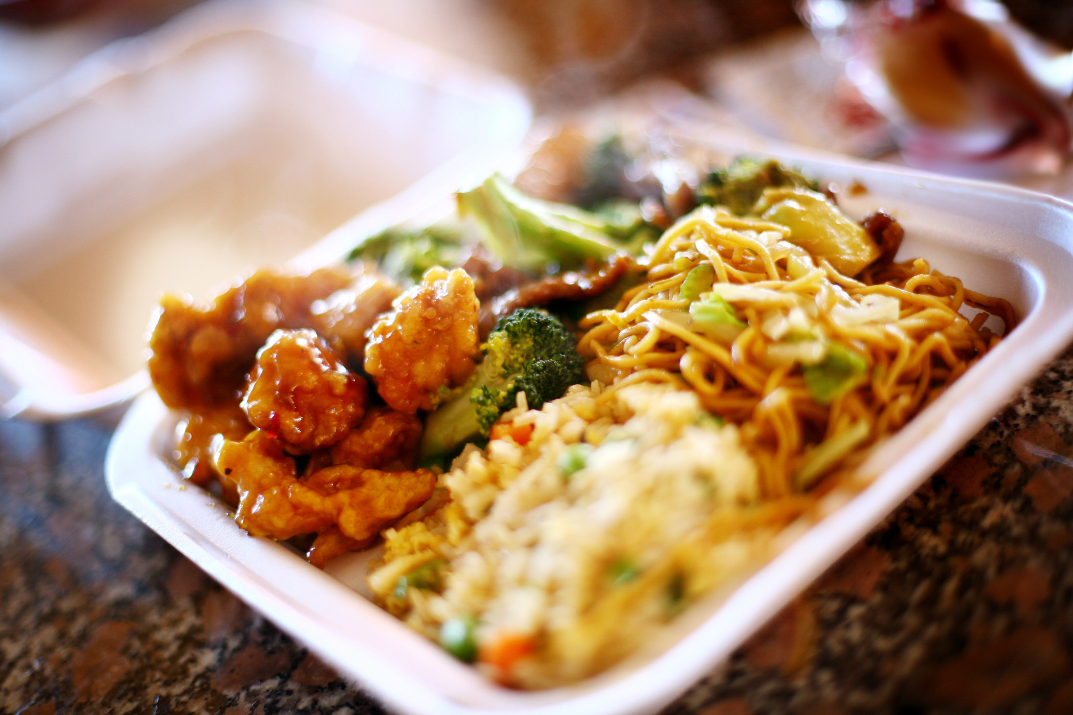 A platter of Chinese food in a takeout container
