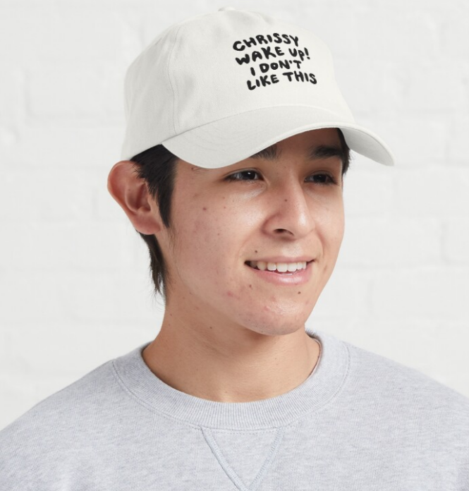 An off white soft baseball hat with text printed on the front