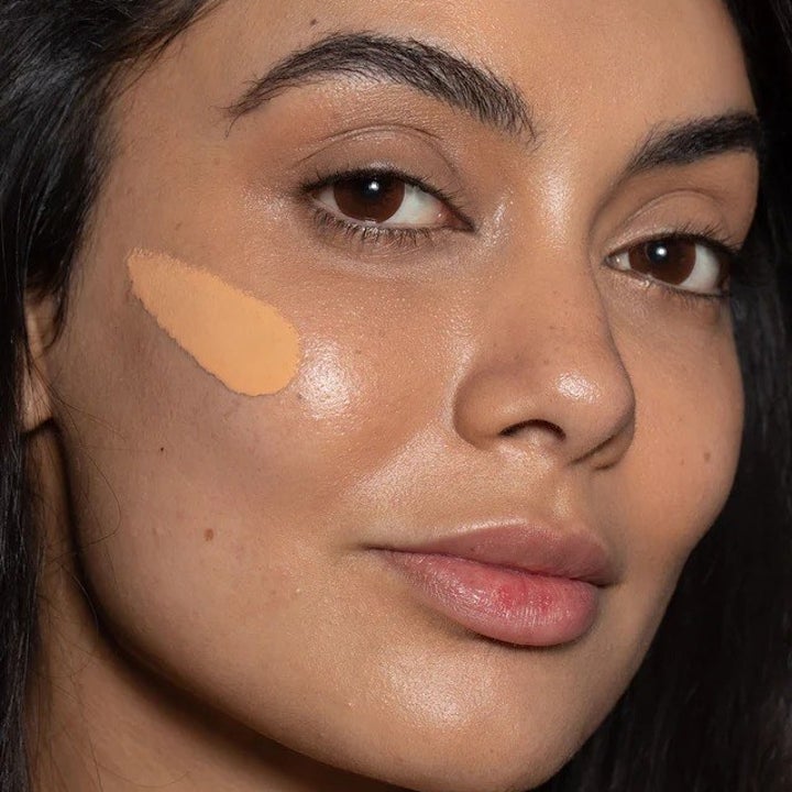 model with medium skin tone wearing Super Serum Skin Tint SPF 40