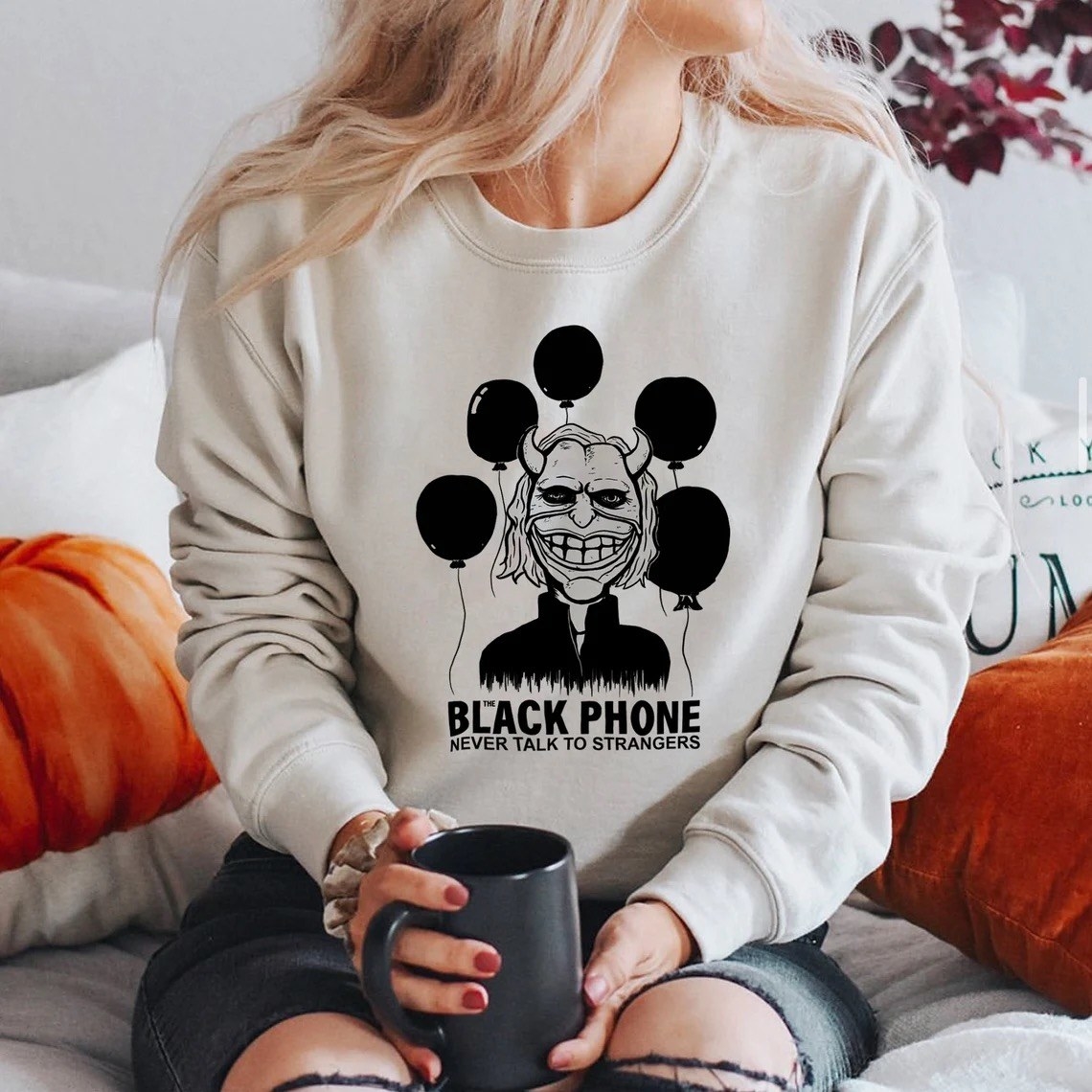 A woman wearing a &quot;Black Phone&quot; T-shirt