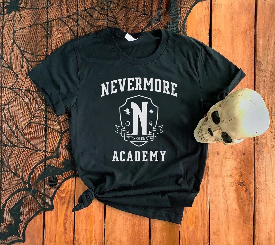 A black t shirt that has the nevermore academy logo printed on the front