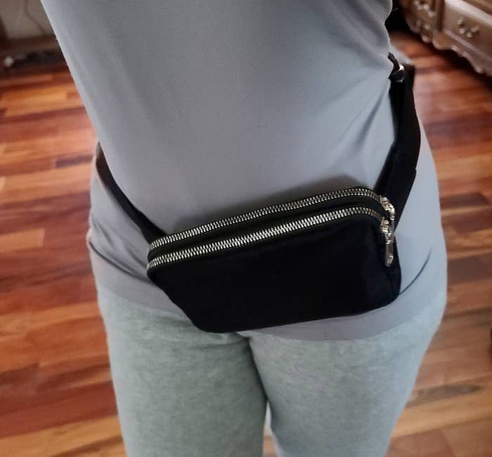 a reviewer wearing the black bag on their hips