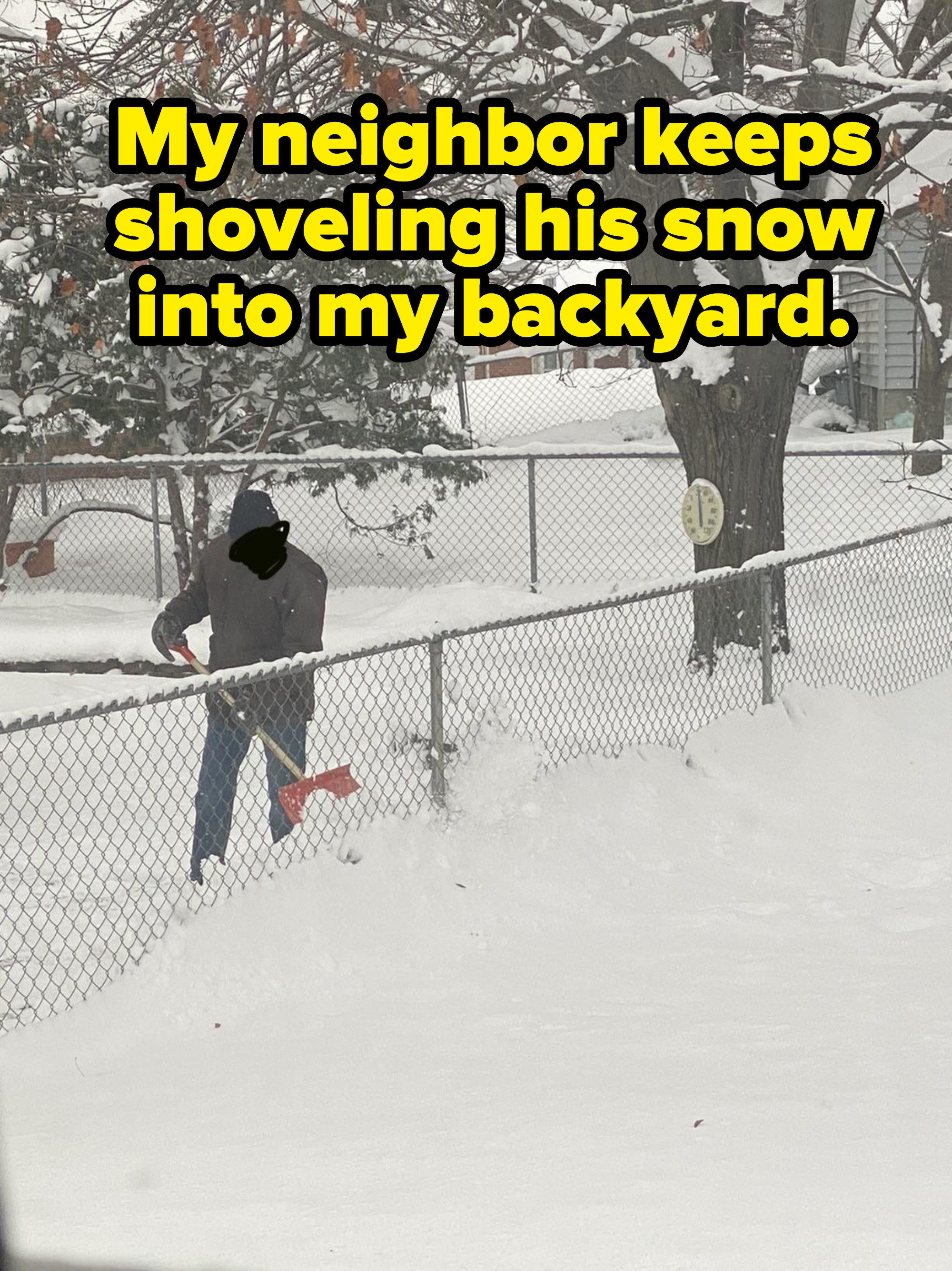 Person shoveling snow through a fence