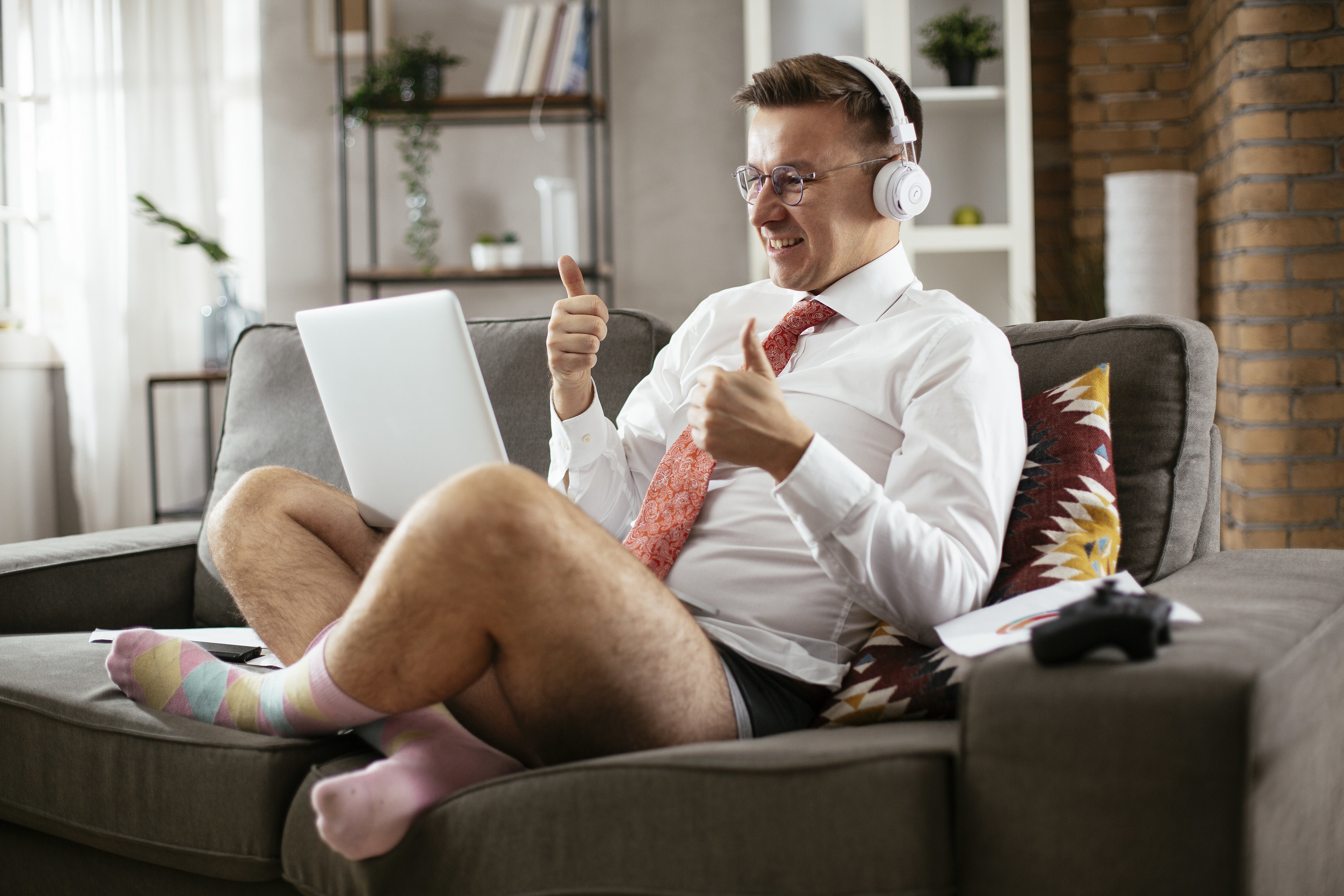 man working from home wearing a dress shirt and tie on the top and underwear on the bottom