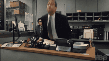 Tom from Succession angrily flipping over a desk