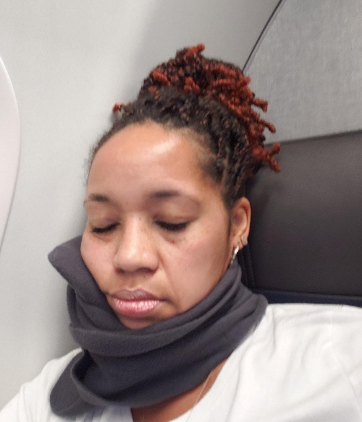 a reviewer using the neck pillow on a plane