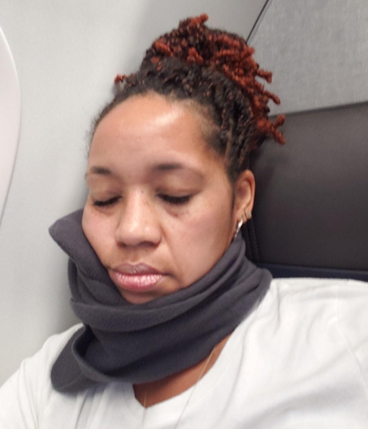 a reviewer using the neck pillow on a plane