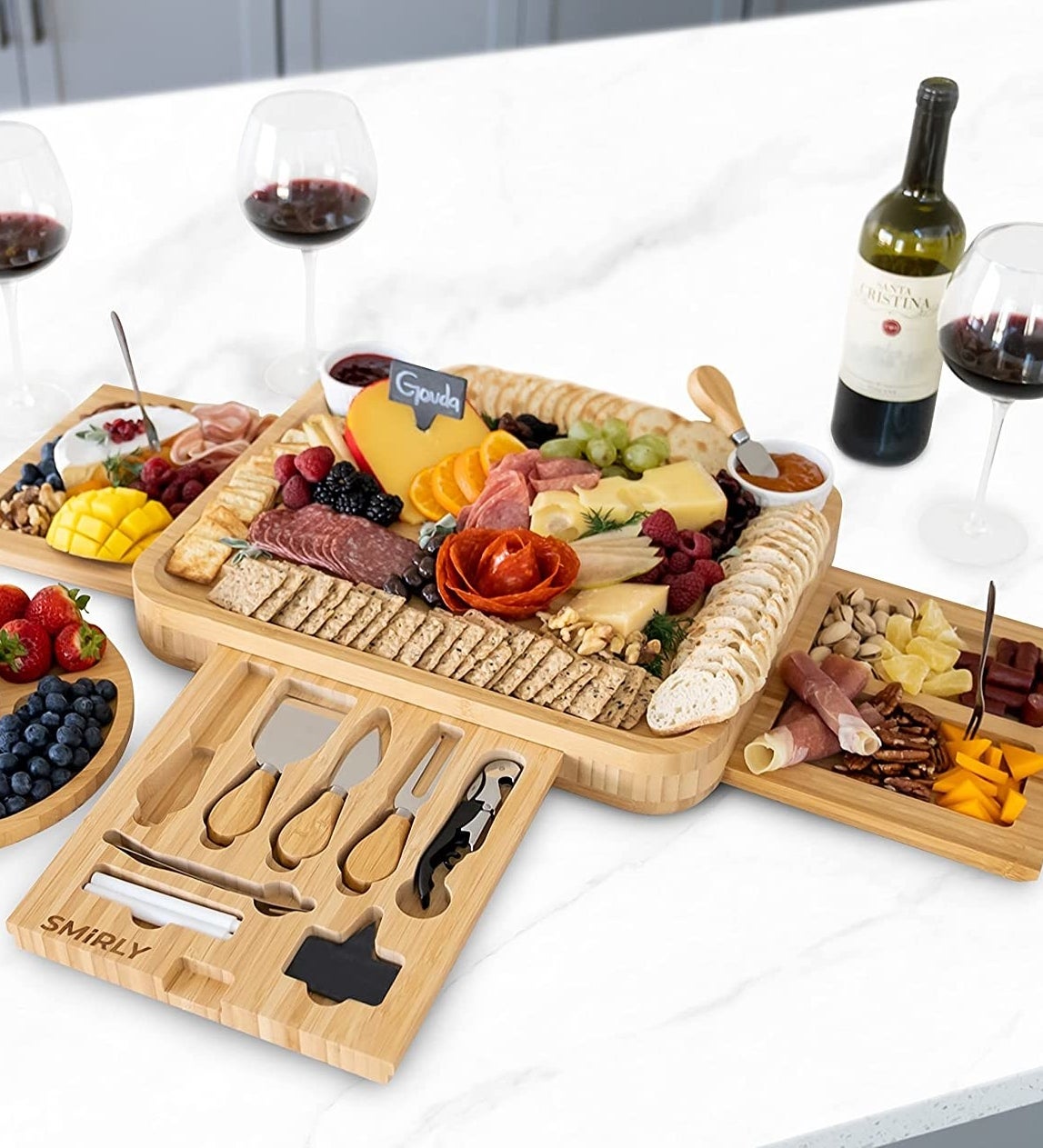 The board on a marble counter filled with meats and cheeses