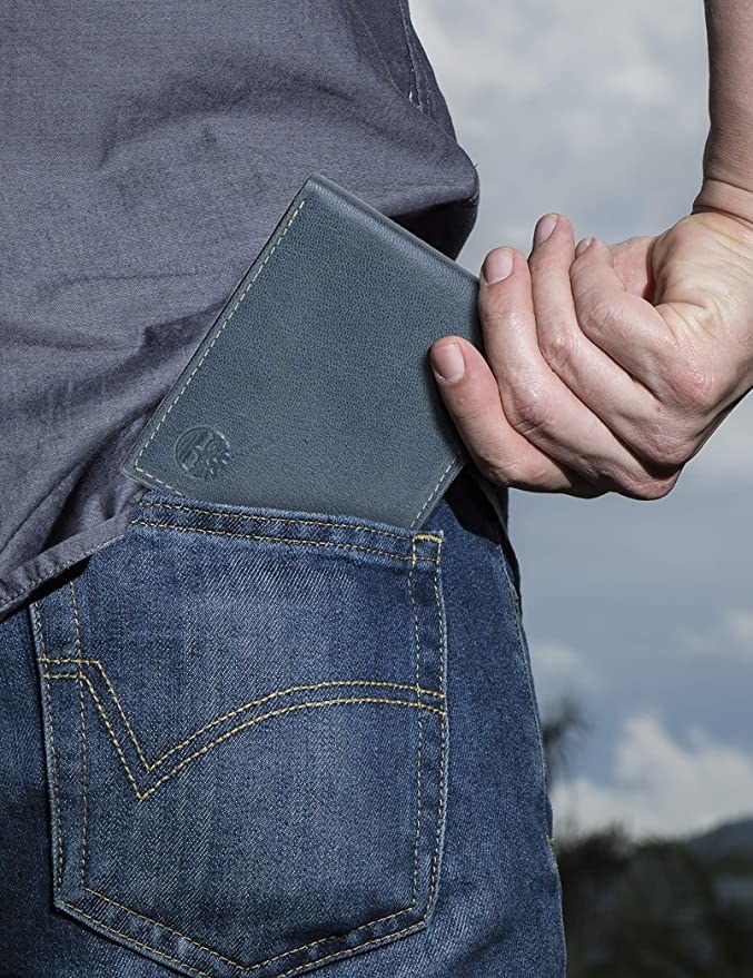 person putting the wallet in their back pocket