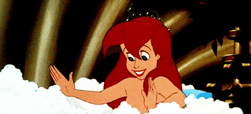 a gif of ariel in the bath blowing a bubble away out of her hands