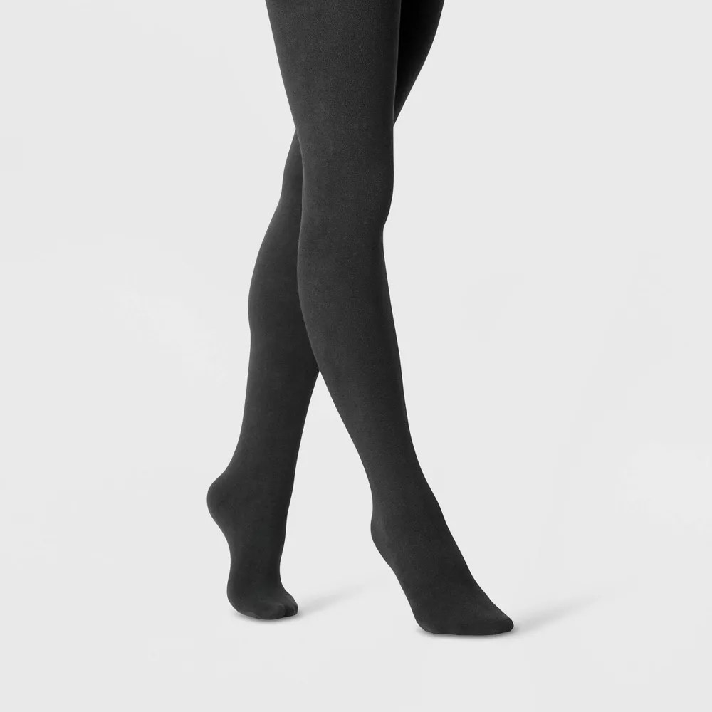 A model wearing the tights in the color Black