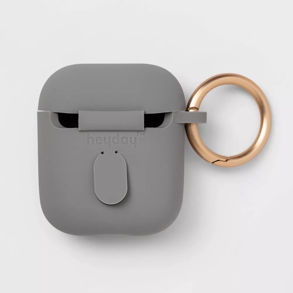A grey AirPods case with a gold-tone clip
