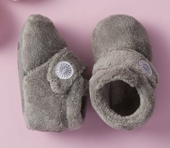 a pair of ugg baby booties with hook and loop closure