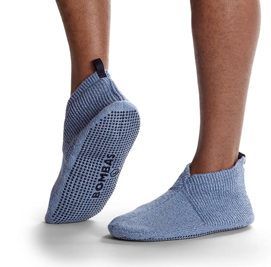 a person wearing a pair of knitted slipper socks with grippy bottoms