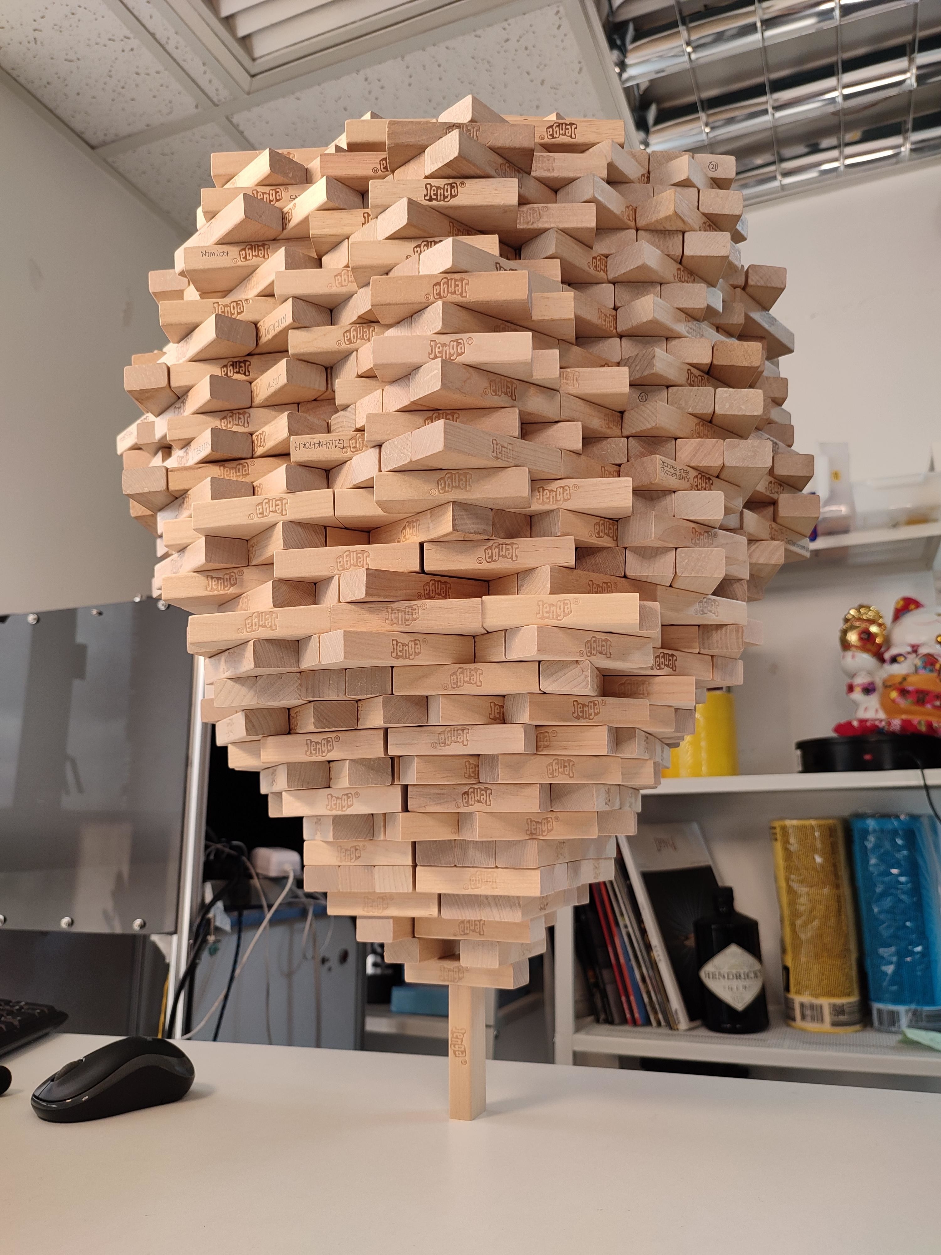 A large reverse pyramid of Jenga pieces set at angles on a table