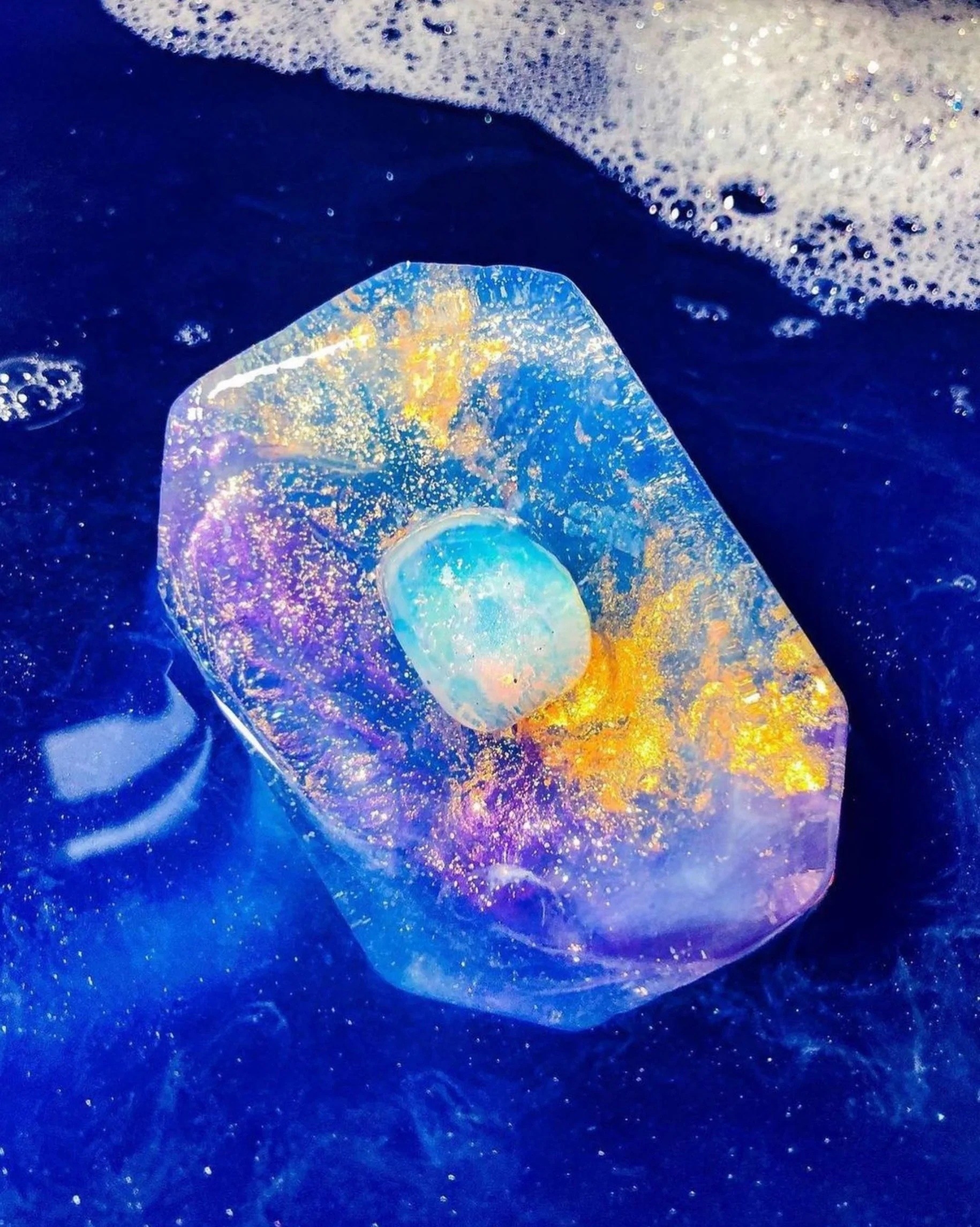 The bar of purple and blue soap with gold glitter, plus the opalite crystal in the center