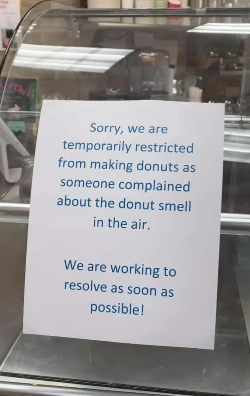 A sign saying a business had to stop making donuts because someone complained about the smell in the air