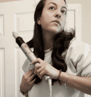 a gif of the author using the shark flexstyle to curl her hair