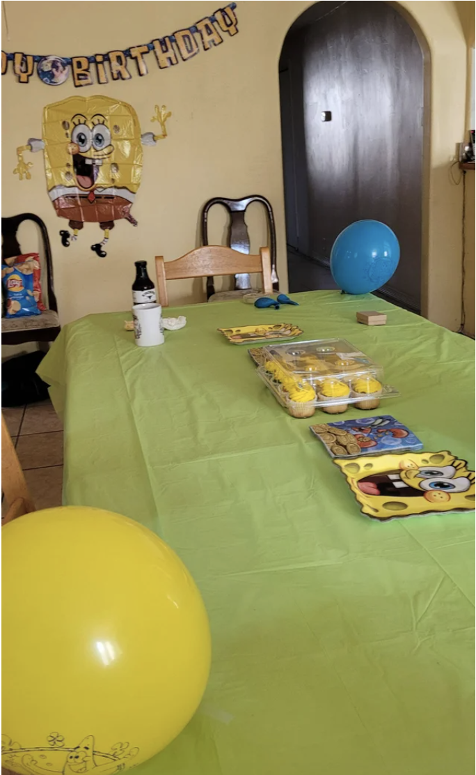 A kitchen decorated with SpongeBob wall hangings, balloons, cupcakes, and plates