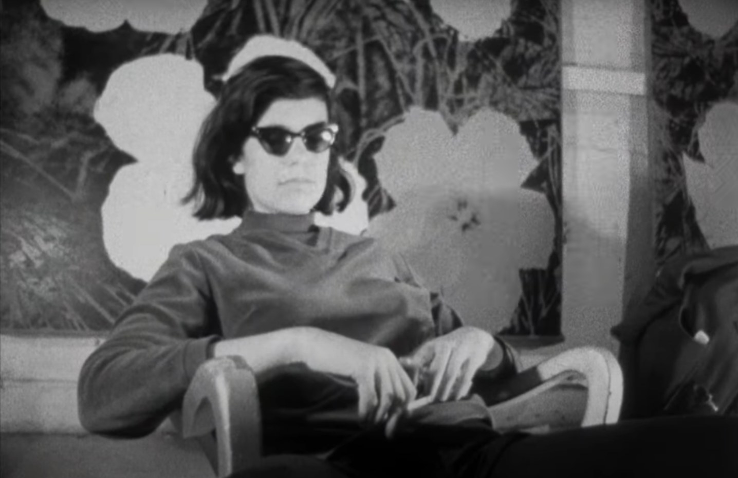 A woman sits in a chair with sunglasses on