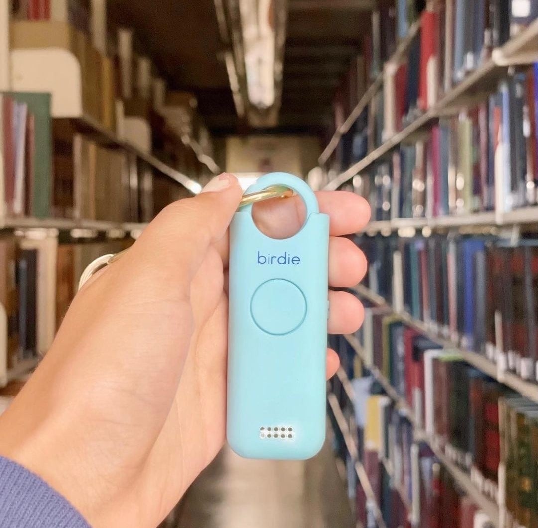 someone holding the alarm keychain in a library
