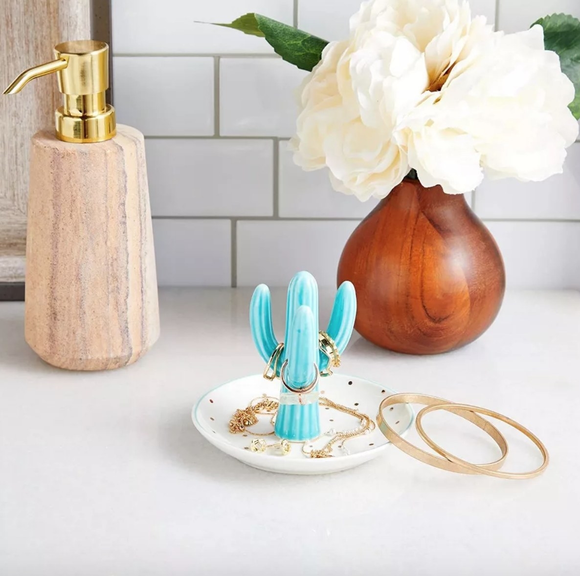 Blue cactus ring tray on counter in front of wooden soap dispenser and wooden vase
