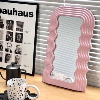 The pink wavy mirror is shown