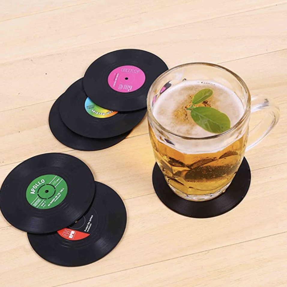 the vinyl coasters on a table with a drink on it