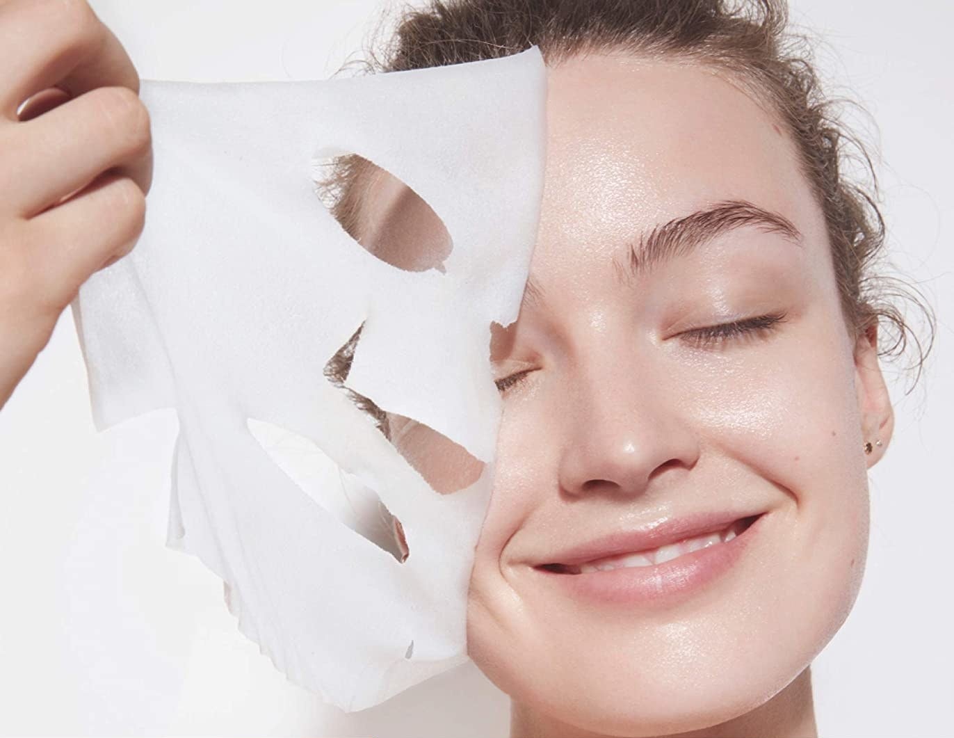 a person taking the sheet mask off their face