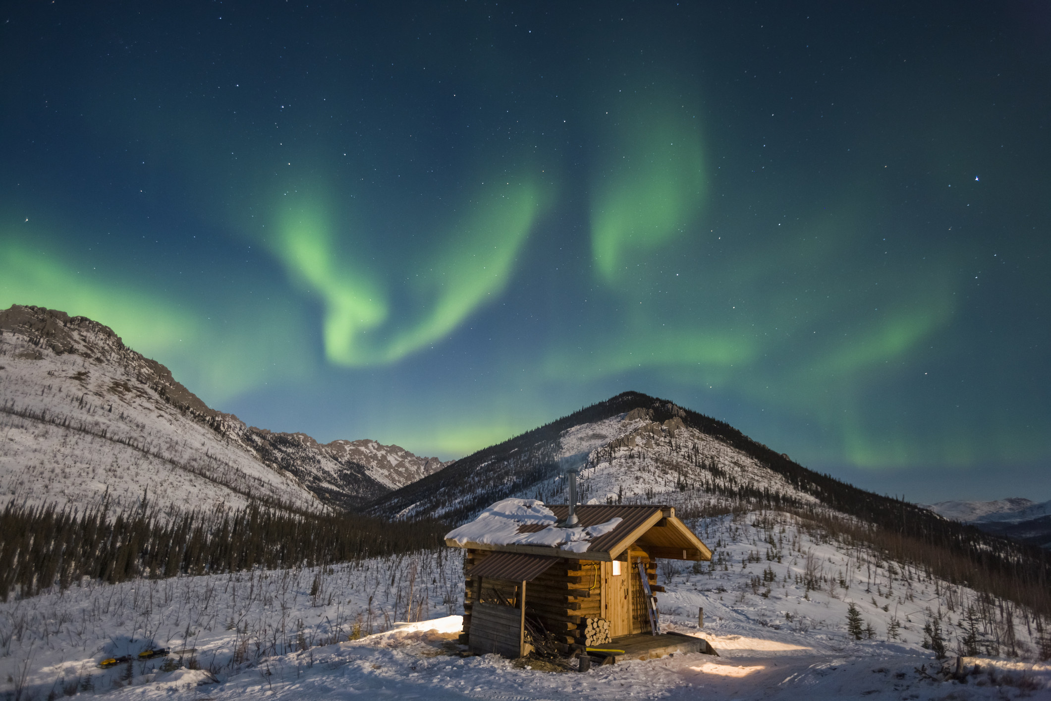 The Northern Lights over a cabin.