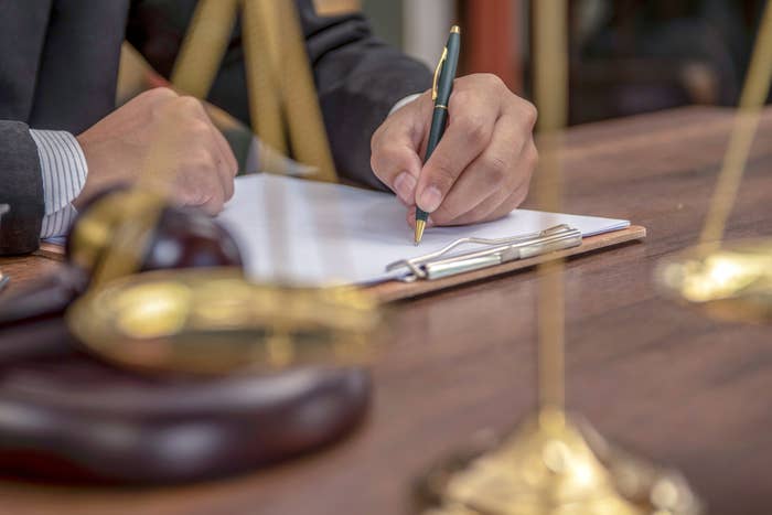 a person signing a document in a courtroom