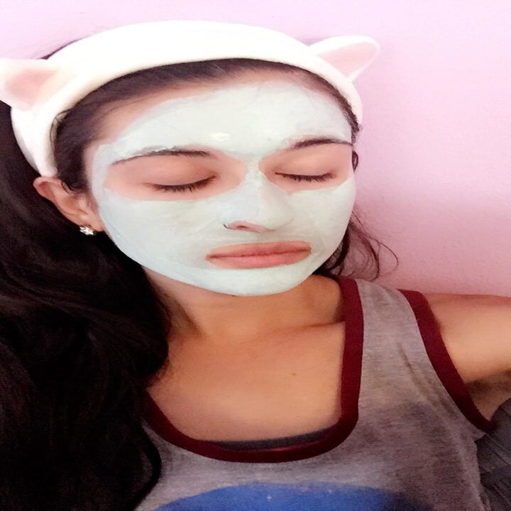 a reviewer wearing the headband with cat ears with a face mask on