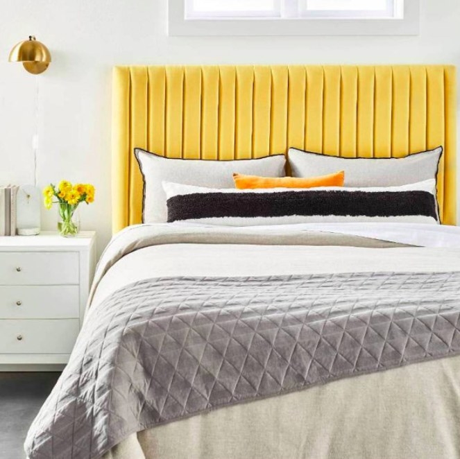 The velvet bed frame in yellow on a bed