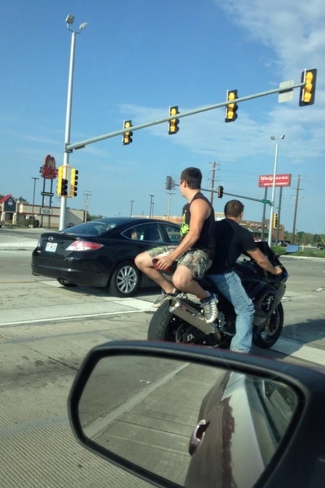 a guy sitting backward on a motorcycle