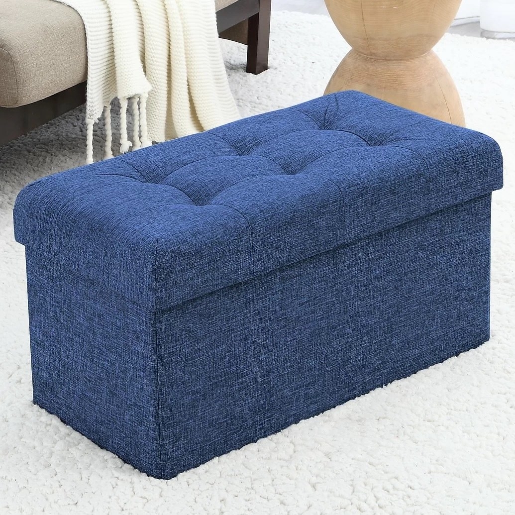 a navy storage ottoman in a living room