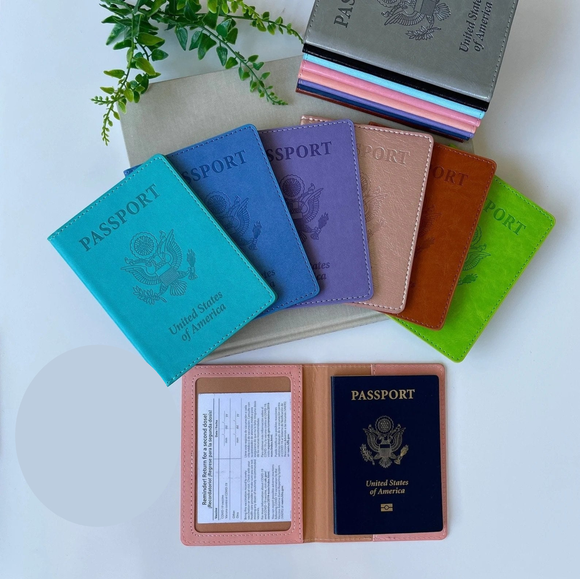 a stack of colorful passports holder, some fanned out, and one passport holder opened to show its contents