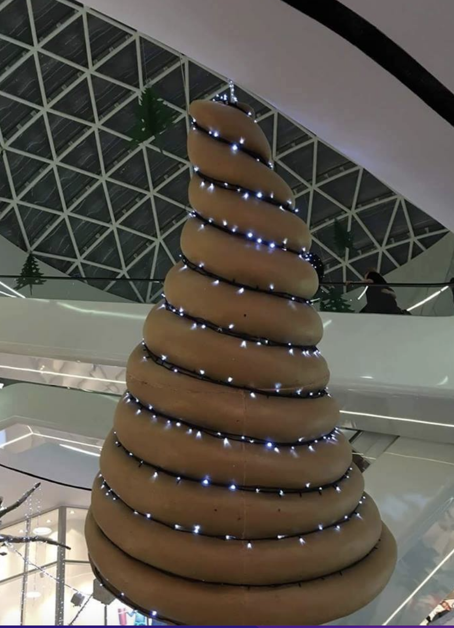 A Christmas tree with a brown wreath that looks like a swirl of feces