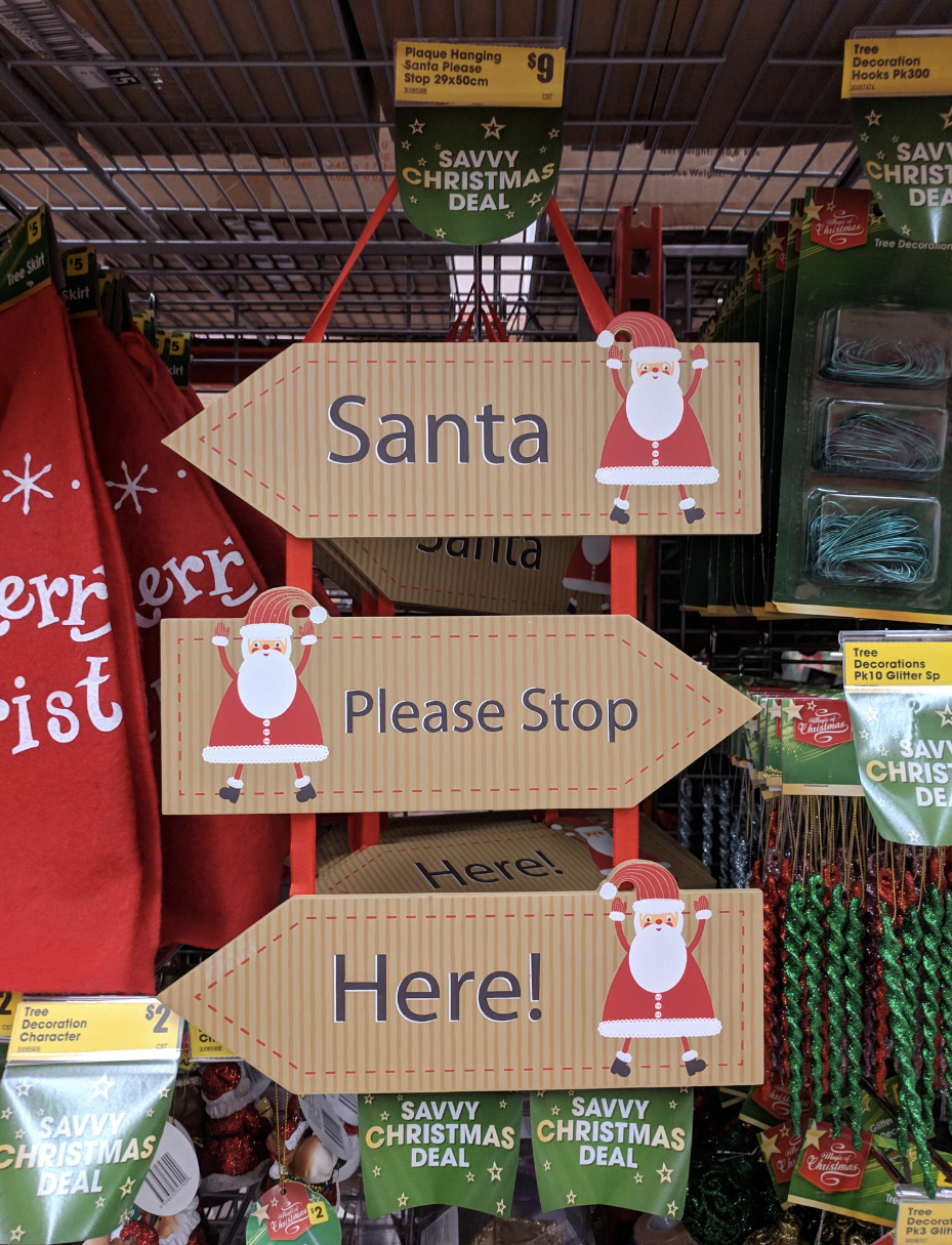 A three-way sign: &quot;Santa&quot; &quot;Please Stop&quot; &quot;Here!&quot;